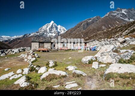 Nepal. Trekking di picco dell'isola. Casa da tè sopra il villaggio di Dingboche con la formidabile cima di Taboche in lontananza. Foto Stock