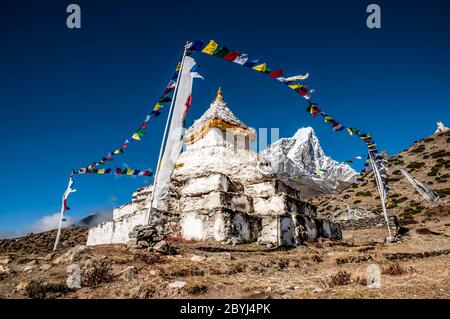 Nepal. Trekking di picco dell'isola. Al Chorten Stupa buddista sopra l'insediamento sherpa di Dingboche con la formidabile cima Taboche in lontananza Foto Stock