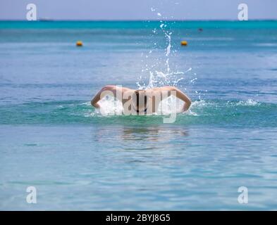 l'uomo sportivo nuota in mare farfalla colpo sty Foto Stock