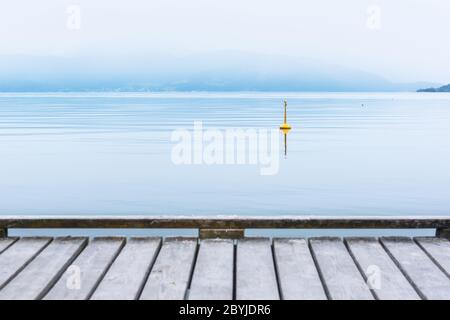 Misty mattina sul villaggio di Norheimsund. Molo di legno sul hardangerfjord, Norvegia, Europa. Fotografia di paesaggio Foto Stock