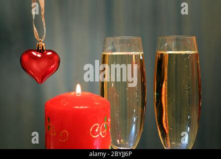 bicchieri con champagne con cuore e candela Foto Stock