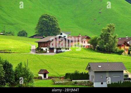 Altdorf, Svizzera - 14 giugno 2017: Splendida vista su un paesaggio montano idilliaco nelle Alpi con chalet tradizionali e fattoria in verdi prati alpini Foto Stock