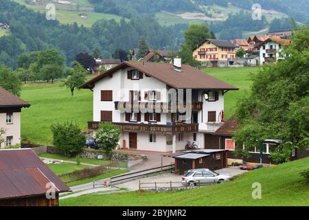 Altdorf, Svizzera - 14 giugno 2017: Splendida vista di idilliaco villaggio di montagna nelle Alpi con chalet tradizionale in verdi prati alpini a Uri ca Foto Stock