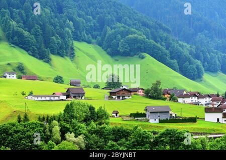 Altdorf, Svizzera - 14 giugno 2017: Splendida vista su un paesaggio montano idilliaco nelle Alpi con chalet tradizionali e fattoria in verdi prati alpini Foto Stock