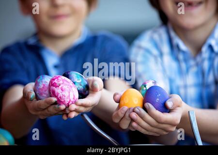 Bambini dolci, fratelli, uova da colorare e da pastare per Pasqua in giardino, all'aperto a casa in cortile Foto Stock