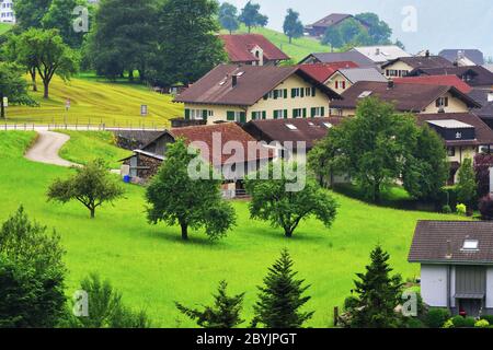 Altdorf, Svizzera - 14 giugno 2017: Splendida vista di idilliaco villaggio di montagna nelle Alpi con chalet tradizionale in verdi prati alpini a Uri ca Foto Stock