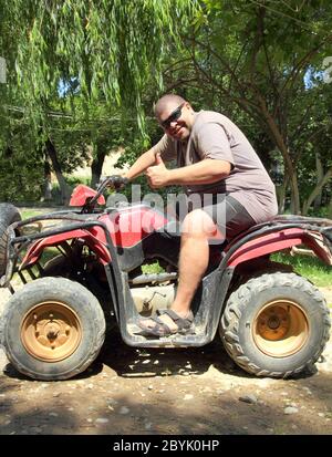 divertente uomo in sovrappeso su quad Foto Stock