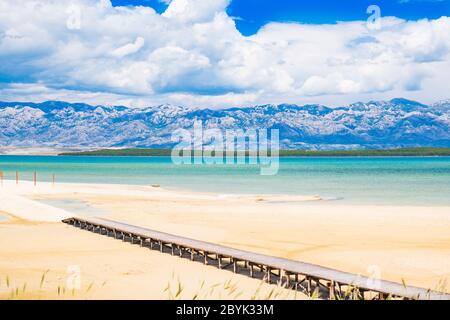 Bella laguna di sabbia vicino alla città di Nin in Dalmazia, Croazia. La costa adriatica e il cielo blu con le nuvole. Velebit montagna sullo sfondo. Foto Stock