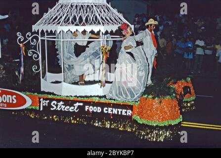 Un galleggiamento in una parata della comunità di Chicano a Los Angeles, California, USA 1970 (Chicanos e Chicanas sono uomini e donne di discendenza messicana). Il giorno dell'indipendenza (Día de la Independencia) è una festa pubblica in Messico il 16 settembre per celebrare la liberazione dal dominio spagnolo nel 1810. Il galleggiante sta pubblicizzando il 1st Street Food Center. Le donne su di esso stanno indossando l'abito tradizionale. Foto Stock