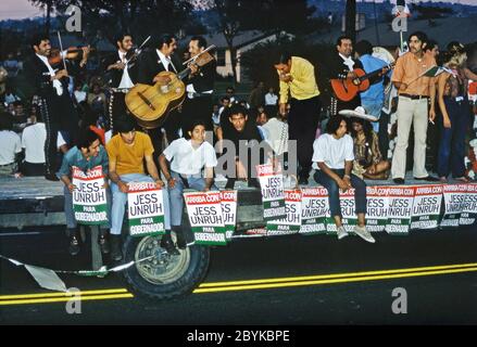 Un galleggiamento in una sfilata della comunità di Chicano a Los Angeles, California, USA 1970 (Chicanos e Chicanas sono uomini e donne di origine messicana). I manifesti indicano il supporto nella comunità per Jess Uruh nella sua candidatura per il governatore di Stato in quell'anno. Inoltre, sul float c'è una band e cantante Mariachi. Jesse Marvin Unruh (1922 – 1987) è stato un politico americano democratico e un tesoriere dello Stato della California. Unruh ha condotto una campagna elettorale senza successo per il governatore della California contro Ronald Reagan. Foto Stock