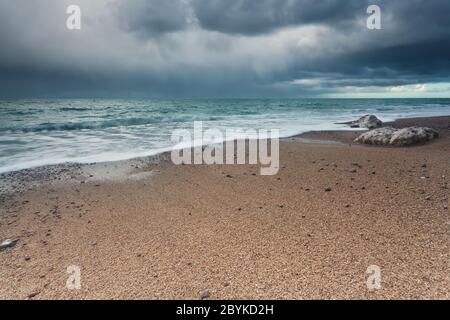 Cielo tempestoso sulla spiaggia di roccia nell'oceano Atlantico Foto Stock