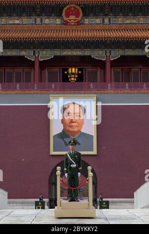 Piazza Tiananmen, ingresso alla Città Proibita. Un soldato cinese è all'attenzione con un ritratto di Mao Zedong dietro le sue spalle. Foto Stock