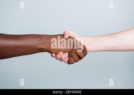Primo piano foto di due mani armi handshake razza diversa amici multinazionali antirazzismo problema aiutare insieme mondo mondo partner relazioni Foto Stock