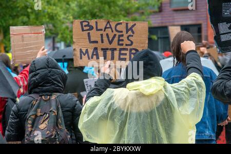 I manifestanti stanno manifestando sotto la pioggia battente nel centro di Enschede per protestare contro l'uccisione di George Floyd e il razzismo negli Stati Uniti. Foto Stock