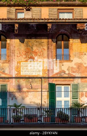 La luce del sole si trova sugli edifici storici che circondano Piazza Erbe, Verona, Veneto, Italia Foto Stock