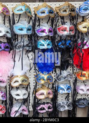 Esposizione di maschere per gli occhi di carnevale multicolore alcune con piume in vendita in un negozio a Venezia, Italia Foto Stock