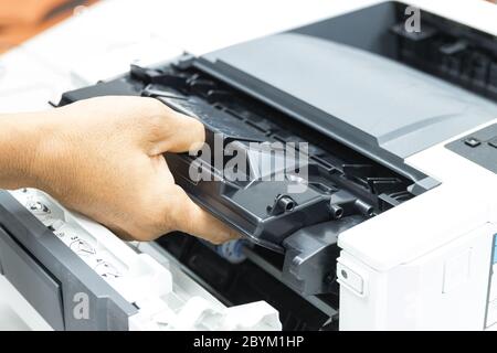 Tecnici che sostituiscono il toner nella riparazione dei materiali di consumo per ufficio della stampante laser Concept Foto Stock