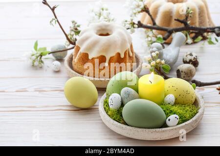 Decorazioni pasquali con uova, muschio e figurine in ceramica. Arredamento festivo Foto Stock