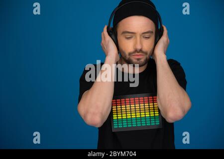 Bello DJ maschio con le cuffie su blu Foto Stock