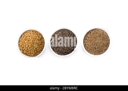 Assortimento di semi diversi in ciotola isolata su fondo bianco. Semi di lino, di cia e di sesamo isolati su sfondo bianco Foto Stock