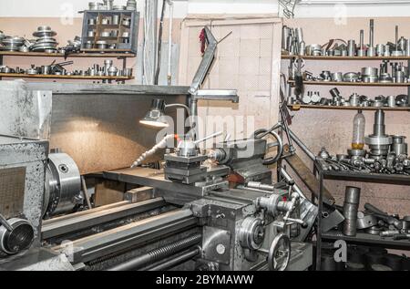 Produzione di tornitura. Stoccaggio di prodotti metallici finiti su scaffali. Usare le vecchie tecnologie in tempi di crisi e stagnazione. Foto Stock