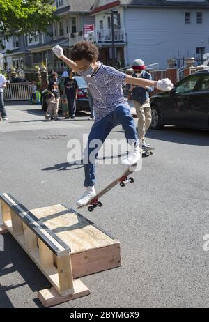 I ragazzi si allenano e si lasciano fare un po' di vapore, skateboard su una strada designata nel quartiere residenziale di Brooklyn Kensington durante il Covid-1 Foto Stock