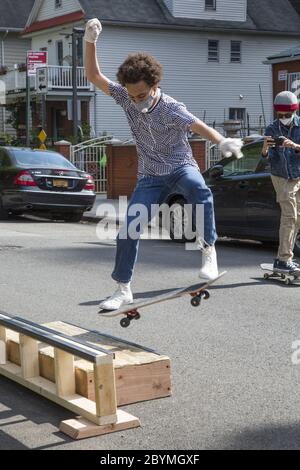 I ragazzi si allenano e si lasciano fare un po' di vapore, skateboard su una strada designata nel quartiere residenziale di Brooklyn Kensington durante il Covid-1 Foto Stock