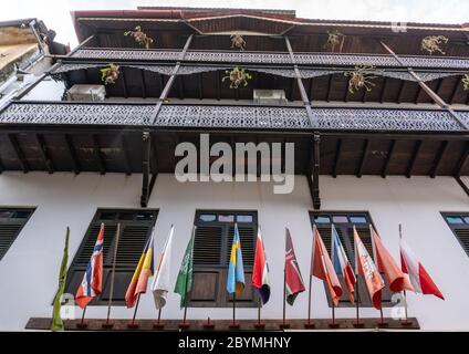 Fascino del White Building con molti paesi Bandiere in Stone Town, la capitale di Zanzibar Foto Stock
