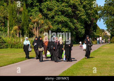 Gruppo di donne musulmane che indossano hijabs neri che camminano nel Regent's Park a Londra, Regno Unito Foto Stock