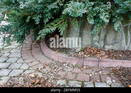 Piccoli ciottoli decorativi e pietre di pavimentazione nel giardino. Giardino hobby Foto Stock