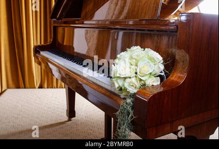 Bouquet di rose bianche che si stenderà sulle chiavi del pianoforte. Decorazioni per feste Foto Stock