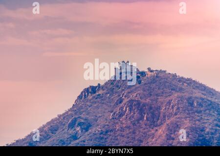 Forte di Sajjangarh sulla cima della collina in Udaipur, Rajasthan, India al tramonto Foto Stock