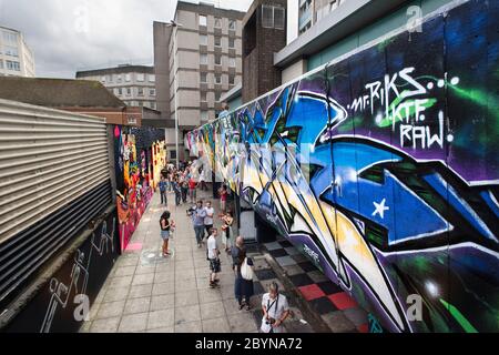 I visitatori del festival See No Evil Art vengono dipinti guardando opere d'arte urbane dipinte all'esterno degli edifici di Nelson Street. Ago 2012 Foto Stock