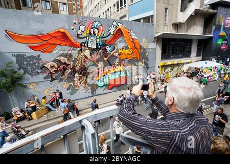 Un uomo scatta una fotografia di opere d'arte di strada urbane dipinte su edifici di Nelson Street come parte del progetto di lavoro See No Evil Art. Ago 2012 Foto Stock