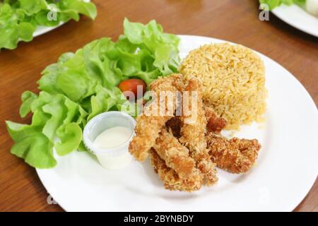 riso fritto e pollo fritto impanato in piatto bianco Foto Stock