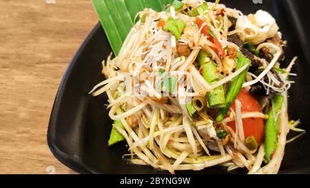 insalata di papaya con vermicelli e granchio salato su piatto nero Foto Stock