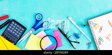 Diversi materiali scolastici su sfondo blu. Concetto Torna a scuola Foto Stock