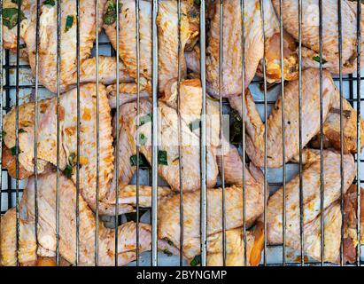 Ali di pollo crude in marinata. Ali di pollo alla griglia Foto Stock