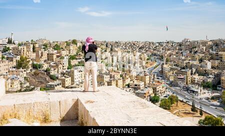 Uomo che guarda Amman Midtown con la bandiera Jordan sullo sfondo Foto Stock
