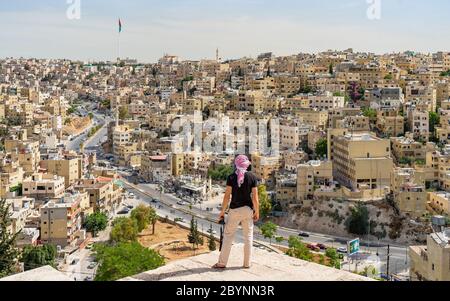 Uomo che guarda Amman Midtown con la bandiera Jordan sullo sfondo Foto Stock