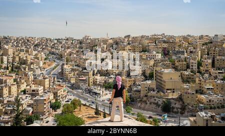 Uomo che guarda Amman Midtown con la bandiera Jordan sullo sfondo Foto Stock