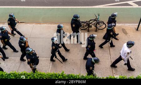 Gli ufficiali della NYPD seguono i dimostranti Black Lives Matter mentre si rialzano lungo la 9th Avenue a Chelsea a New York per protestare contro la morte di George Floyd, vista lunedì 1 giugno 2020. (© Richard B. Levine) Foto Stock