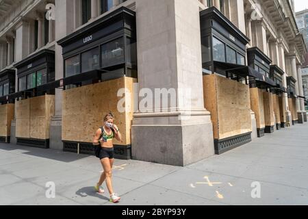 La donna passa accanto a Lego ed Eataly nel quartiere Flatiron di New York si è imbarcata in attesa di una ripetizione di saccheggi e vandalizzazione associati alle proteste legate alla morte di George Floyd, avvenuta mercoledì 3 giugno 2020. (© Richard B. Levine) Foto Stock