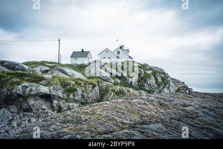 Un faro sulle scogliere sul Lofoten nel nord della Norvegia in un giorno nuvoloso Foto Stock