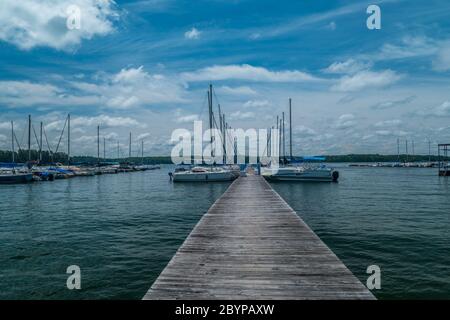 Una splendida vista che guarda giù dal molo alle barche di tutti i tipi ormeggiate presso i moli in una giornata di sole luminoso in estate Foto Stock