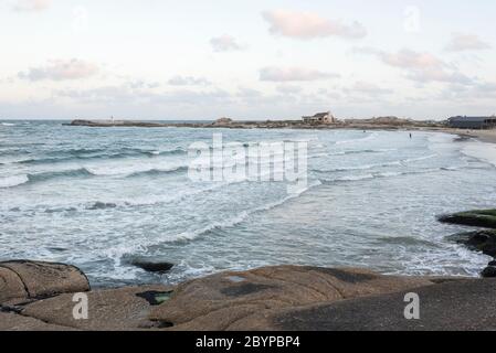 Mare tranquillo, spiaggia di pescatori a Punta del Diablo, Rocha, Uruguay, un pomeriggio estivo Foto Stock