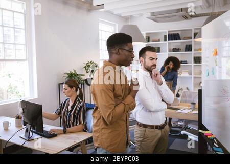 Multiregazioni imprenditori si chiedono di fronte a una tavola Foto Stock