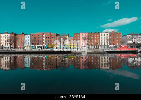 Dublino / Irlanda : gli edifici si riflettono in una calma acque del fiume Liffey lungo Ormond Quay a Dublino durante una giornata di primavera irlandese molto soleggiata Foto Stock