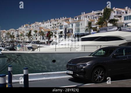 Maserati Levante SUV parcheggiato di fronte a Yacht a motore Puerto Banus Marina Andalusia Spagna Foto Stock