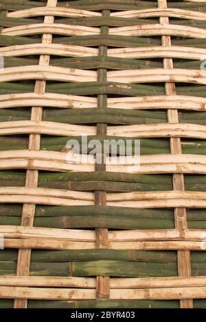 Tessuto di bambù trama sfondo design naturale artigianato verticale. Natura sfondo di verde e giallo artigianato tessitura superficie di bambù tessitura. Foto Stock